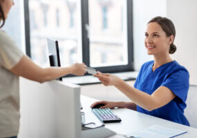 medicine, people and healthcare concept - happy smiling female doctor or nurse and patient with insurance or credit card card at hospital